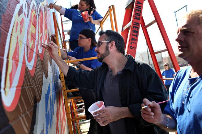 Las Vegas artist Jerry Misko, center, works on a mural in the arts district funded by "Extreme Home Makeover"  to accompany the home the show is re-building in Las Vegas, on Monday, March 16, 2009. 