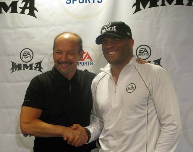 UFC legend Randy Couture, right, shakes hands with EA Sports president Peter Moore after the announcement Saturday that Couture will appear in company's upcoming "MMA" video game.

