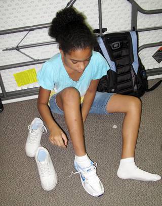 Olivia Rotta tries on a new shoe brought to her by a Zappos employee.