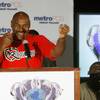 Oliver McCall holds up his fists during a news conference as his opponent Franklin Lawrence listens 