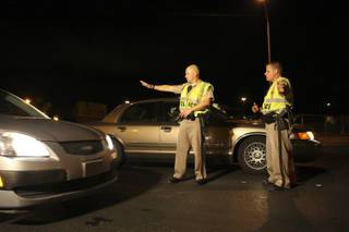 Metro Police officers Chris Same and Steve Hutchason, right, stop a vehicle while looking for impaired drivers Saturday evening at a DUI checkpoint on Rainbow Boulevard north of Cheyenne Avenue.