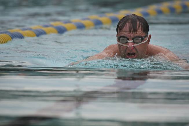 Walt Muir gets some exercise swimming the breaststroke while his grandchildren play in the water Saturday during closing day at Boulder City Pool.