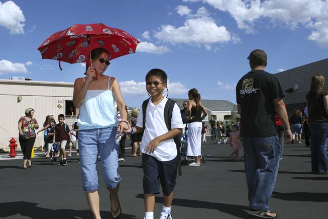 Third grader Shane Collado laughs with his mom, Mary Ann, on the playground after the first day of classes Monday at Steve Schorr Elementary School in Henderson.