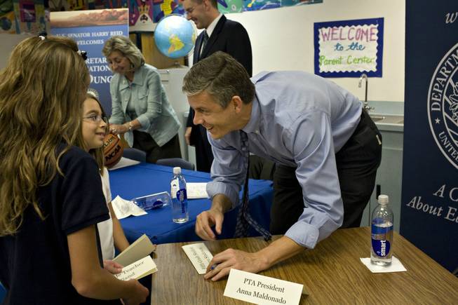 Fifth-grader Faylen Lopez, second from left, gets U.S. Education Secretary Arne Duncan's autograph on her name card following a "Listening and Learning" forum at Harley Harmon Elementary School in Las Vegas on Wednesday, Aug. 26, 2009. 