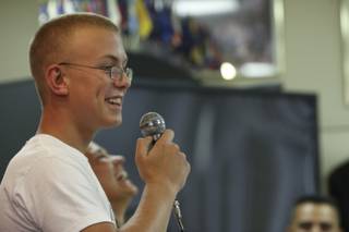 Graduate Zac Kundysek laughs with the audience as he shares his early desire to quit the Devil Pup program but persevered due to liaison representative Marie Tomao (in background) while speaking Sunday during the 2009 Devil Pups Awards Ceremony.
