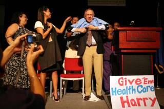 Sen. Harry Reid receives a medical scrub shirt signed by SEIU members at the close of a Nevada State Democratic Party health care rally in the UNLV student union in Las Vegas on Monday night, Aug. 31, 2009.