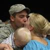 Senior Airman Matthew Ohara greets his wife, Julie, with a kiss after returning from a four-month de