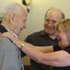 World War II veteran Warren Hogue reacts with joy when surprised by his nephew, Dick Hogue, and his 