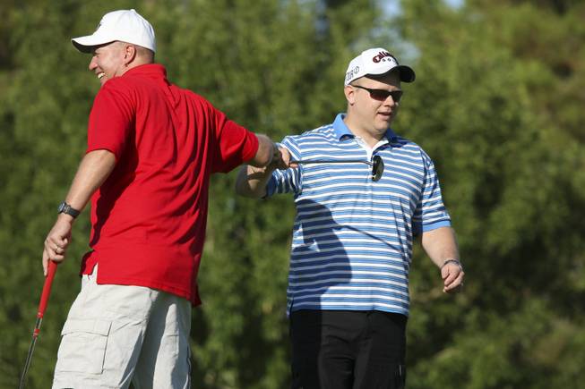 John Gregg and Eric Webster, of the Henderson Police Officers Association, pump fists after a putt during the annual charity tournament hosted by Boulder City resident Andrew Levine at Boulder City Municipal Golf Course.  Levine's father, Robert Levine, died Sept. 11, 2001, in the World Trade Center's South Tower in New York.