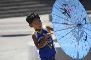 Raegan Kaai, 4, twirls his umbrella around the Henderson Events Plaza Saturday during the Pacific Islands Festival.