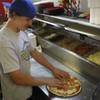 Boulder City High senior linebacker Steven Kaposta adds meat toppings to a pizza while working after football practice in his family's restaurant, Tony's Pizza.