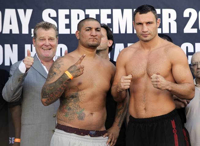 Cristobal Arreola, center, and WBC heavyweight champion Vitali Klitschko, right, pose at the weigh-in for their Saturday boxing match as promoter Dan Goossen gestures, Thursday, Sept. 24, 2009, in Los Angeles.