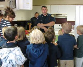 Boulder City firefighter-paramedic Bill Wilson shows first and second graders from Grace Christian Academy a fist on his arm as he explains that any burn larger than that warrants a call to 911 during a tour of the fire station Oct. 1. He talked about kitchen safety as he showed them the station kitchen, where firefighters cook their meals.