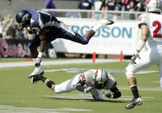 UNR's Brandon Wimberly leaps over UNLV's Travis Dixon during the first half in Reno at Mackay Stadium on Saturday, Oct. 3, 2009.