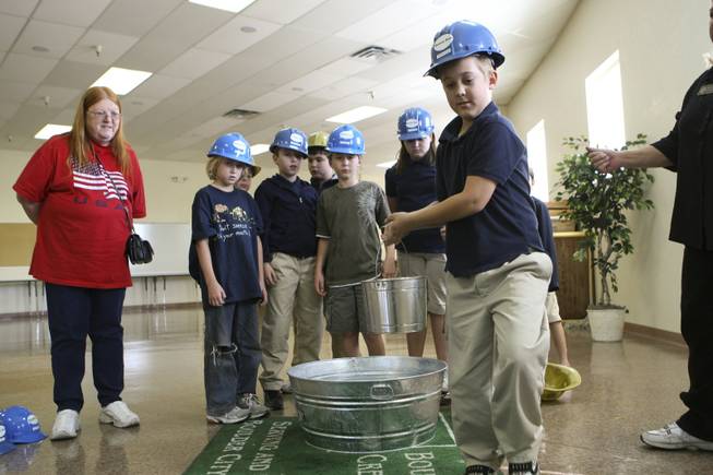 Third grader Jeremiah Roach simulates hauling pails of river water ...