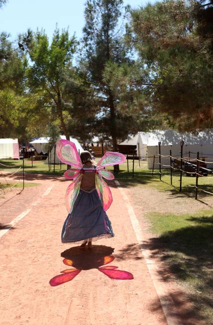 A festivalgoer fairy walks down the path at the annual ...