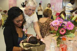 Amber Marcelin-Flynn introduces her 2-week-old daughter, Whitney Sarah Marie, to Angel Julie Goe on Saturday during Nevada's largest military baby showerat Nellis Air Force Base. Flynn's husband, 1st Lt. Dennis Flynn, is serving in Afghanistan with the Army National Guard.
