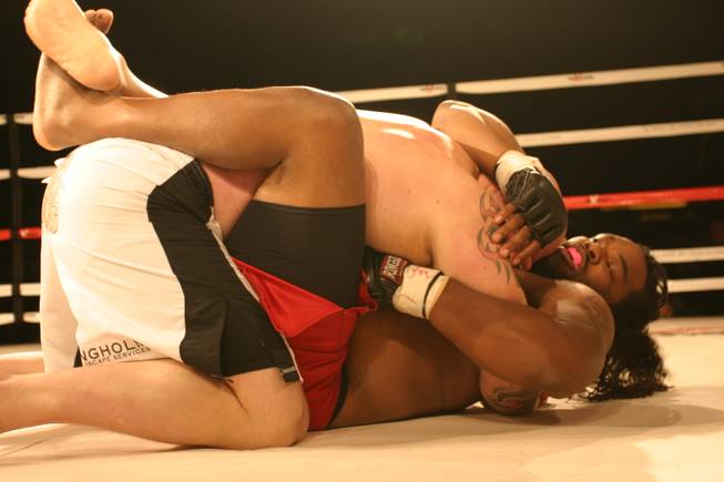 Josh Burns wrestles with Kelly Gray at MMA Xplosion at the M Resort. Gray went on to win the heavyweight bout.