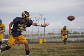 Senior quarterback Ross Lamarca pitches the ball while running offensive drills during practice at Boulder City High.
