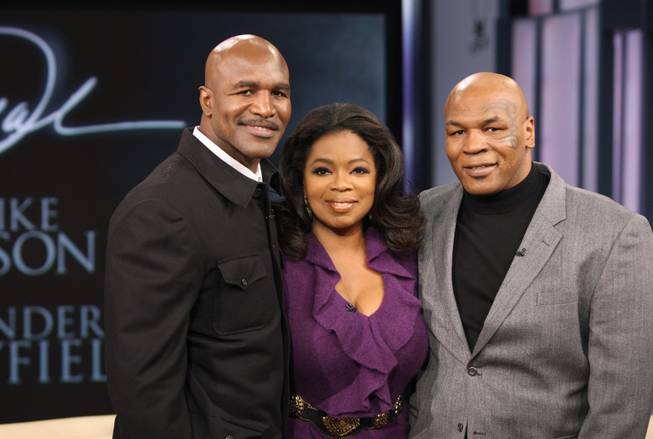In this photograph provided by Harpo Inc., talk show host Oprah Winfrey poses with former world champion boxers Evander Holyfield, left, and Mike Tyson on <em>The Oprah Winfrey Show</em> on Oct. 16, 2009, in Chicago.