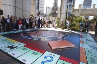 Finalists and passersby gather around the 25-by-25 foot big Monopoly board in preparation for the start of the Monopoly 