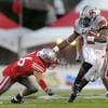 UNLV quarterback Omar Clayton stiff-arms New Mexico's Frankie Baca during Saturday's game.  UNLV won 34-17.
