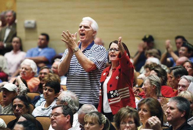 A couple get out of their seats during the forum. Titus had arranged for questions to be written on index cards.