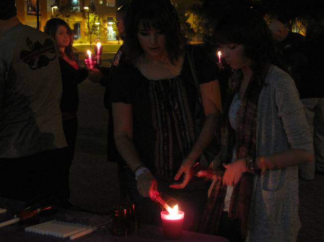 Lauren Fetto, left, lights her candle at a vigil held outside of the UNLV Student Union in memory of teens who have died in car crashes as part of the National Teen Driver Safety Week.