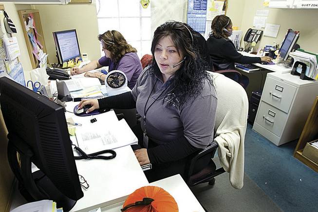 Giselle Sanchez, center, Carolyn Graham, left, and Belinda Brooks are among 13 operators statewide who field calls to Nevada's 2-1-1 help line, which tries to match people in need with public services.
