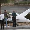 Investigators look over an experimental plane after the pilot made a forced landing on Rancho Drive 