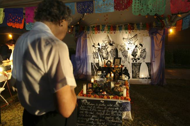 Rosaura Sanchez pays respect at the altar in memory of Jose Guadalupe Posada, a Mexican engraver, illustrator and artist, at the annual Life in Death: Day of the Dead Festival Sunday night at the Winchester Cultural Center and Park.
