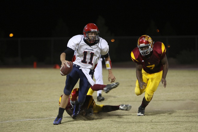 Coronado quarterback RJ Newton breaks a tackle as he carries the ball up field to score a touchdown in the first quarter against Del Sol Friday night. Coronado lost 46-26 as Del Sol clinched the Southeast Division title.