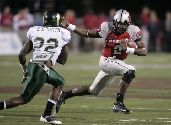 UNLV quarterback Omar Clayton scrambles under pressure from Colorado State defensive back Elijah-Blu Smith during the first half of Saturday's game at Sam Boyd Stadium.