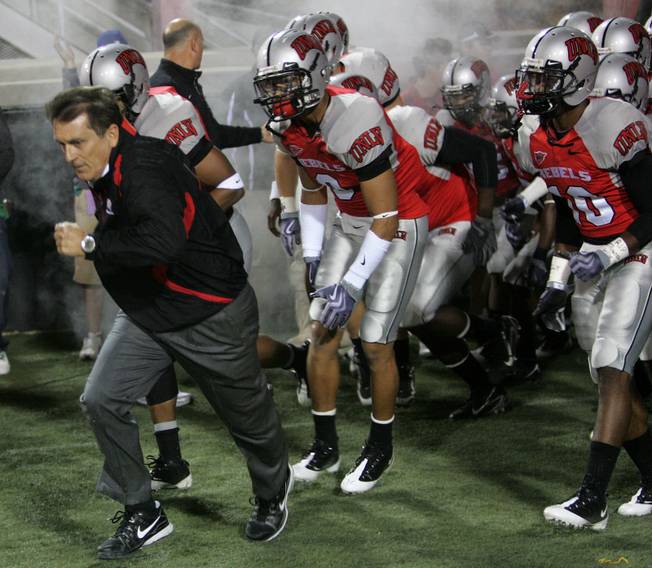 Head coach Mike leads his team out onto the field to take on Colorado St. at Sam Boyd Stadium Saturday.  UNLV came out on top 35-16..