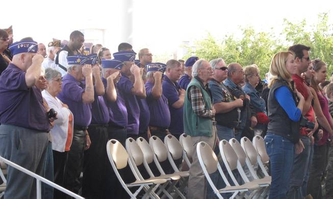 Veterans and friends salute during the singing of the National Anthem at Henderson's Veterans Day Ceremony Saturday.