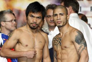 Manny Pacquiao, left, of the Philippines and WBO welterweight champion Miguel Cotto of Puerto Rico pose during an official weigh-in at the MGM Grand Garden Arena on Friday, Nov. 13, 2009. The boxers will fight at the arena on November 14.  
