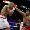 Miguel Cotto (L) takes a punch from Manny Pacquiao during their WBO welterweight title fight Saturda