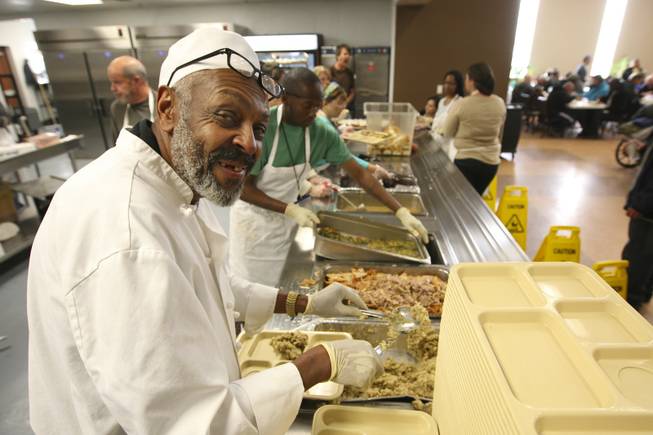 Eddie Motley, 66, a resident of the Las Vegas Rescue Mission, serves up stuffing he helped prepare for the annual Thanksgiving community dinner Wednesday night.