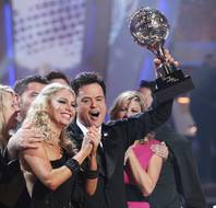 Kym Johnson and Donny Osmond with the champion's mirrored disco ball trophy on the Season 9 finale of ABC's <em>Dancing With the Stars</em>.