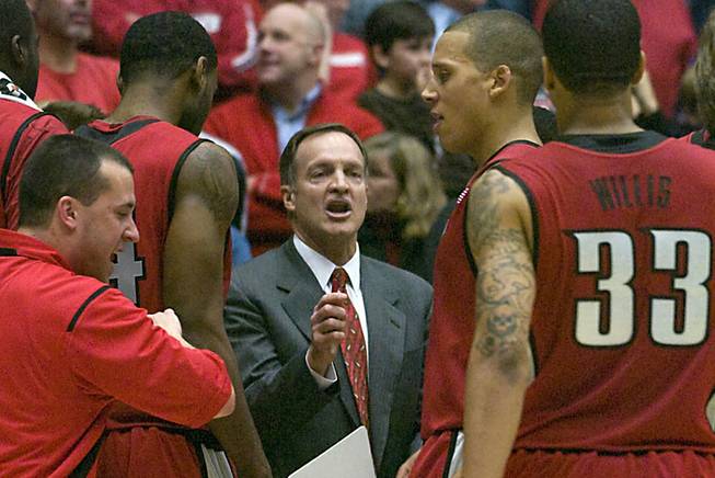 UNLV coach Lon Kruger, center, talks to his team during a during a second-half timeout against Arizona. UNLV won in double overtime, 74-72.