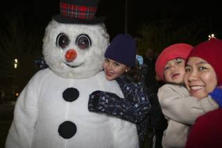 Kailee Fisher, 6, gives Frosty the Snowman a big hug Friday night during the WinterFest celebration at the Henderson Events Plaza.  Standing to the right is Virgie Rosal and her son, Isaac, 2.
