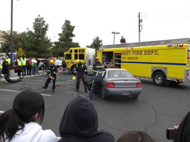 Clark County firefighters prepare to demonstrait the Jaws of Life to open a car in a mock DUI crash.