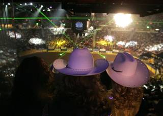 Women in cowgirl hats watch the start of the 10th and final go round of the 2009 National Finals Rodeo Saturday, Dec. 12, 2009, at the Thomas & Mack Center.
