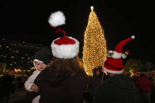 Wearing festive holiday hats, the Madrigale family watch as the Christmas tree is lit Saturday night at the M Resort.