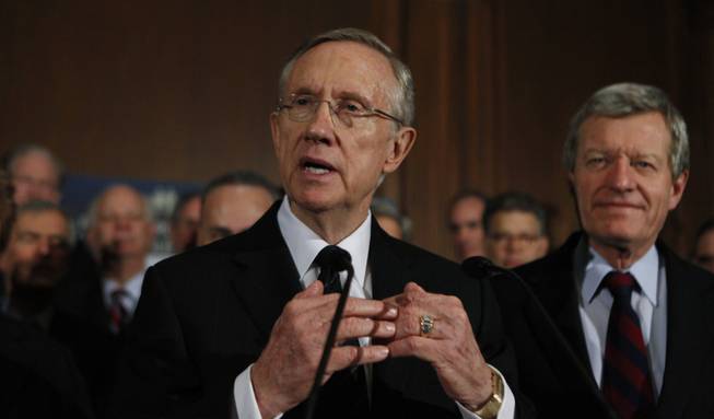 Senate Majority Leader Harry Reid of Nev., left, accompanied by Senate Finance Committee Chairman Sen. Max Baucus, D-Mont., right, and Senate Democrats, gestures during a health care news conference on Capitol Hill in Washington, Wednesday, Dec. 23, 2009.
