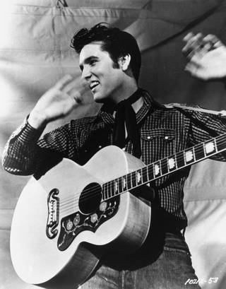 Elvis Presley poses with his Gibson J-200 guitar in an MGM studio publicity photo from the 1950s. Presley will be reunited with Sun Records as part of a licensing agreement between the owner of the historic label and the singer's estate. Sun Entertainment Corp. of Nashville announced the agreement with Elvis Presley Enterprises Inc. Thursday, Oct. 12, 2006. 