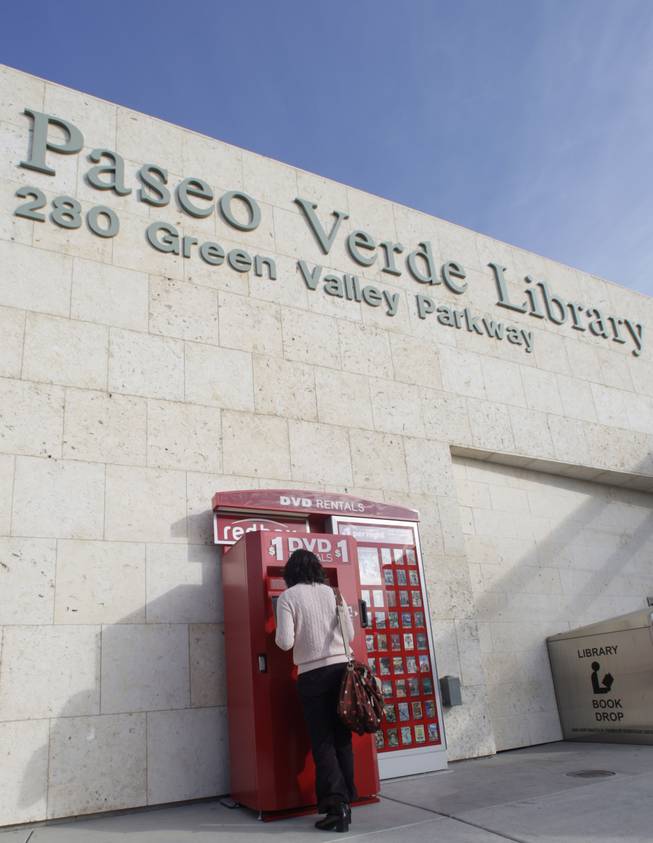 Amy Choi checks the selection of movies at a Redbox DVD movie kiosk in front of the Paseo Verde Library in Henderson on Tuesday. The Paseo Verde Library and the Green Library recently added the rental kiosks.