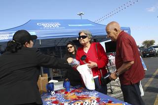 Francis and Rafael Lara, right, pick up free gifts and pamphlets at the tables Wednesday while attending the 2010 Census Portrait of America Road Tour event at Cardenas Market in Las Vegas.