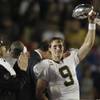 New Orleans Saints quarterback Drew Brees (9) holds the Vince Lombardi Trophy after the NFL Super Bowl XLIV football game against the Indianapolis Colts, in Miami, Sunday, Feb. 7, 2010. The Saints won 31-17. 