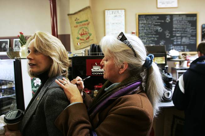 Dr. Patricia Wright uses Sue Lowden's back to write down contact information at Cowboy Joe in Elko Saturday, February 20, 2010 during Lowden's campaign tour of Lincoln Day events in Northern Nevada.